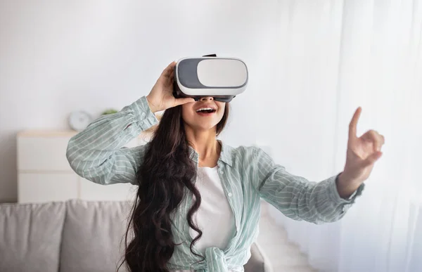 Mujer india feliz en gafas VR interactuando con la realidad virtual, explorando el ciberespacio, jugando videojuegos en casa — Foto de Stock
