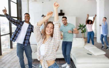 Çeşitli arkadaşlarıyla dans eden ve evde bira içen neşeli beyaz kadın.