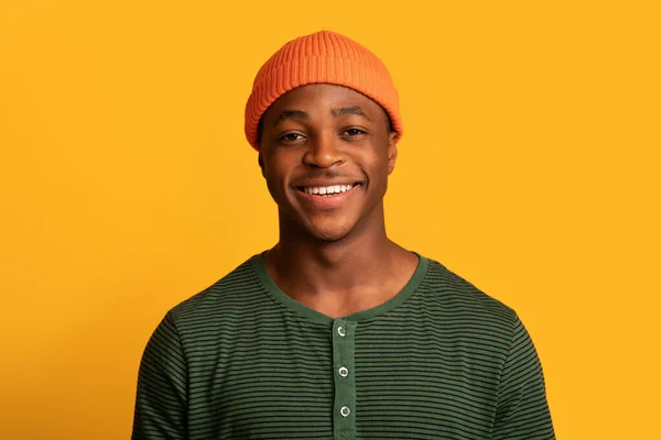 Retrato de alegre jovem afro-americano cara no laranja chapéu sorrindo para câmara — Fotografia de Stock