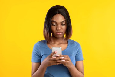 Ciddi Afro-Amerikan Kadın Telefon Kullanımı Sarı Arkaplan Üzerinde