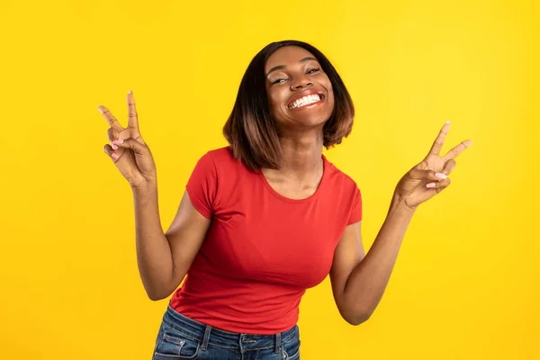 Africano mulher americana Gesturing V-Sign símbolo da vitória sobre fundo amarelo — Fotografia de Stock