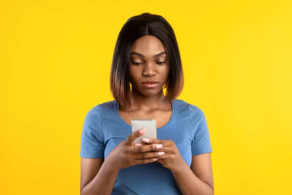 Súlyos afro-amerikai nő használ mobiltelefon sárga háttér — Stock Fotó