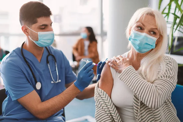 Senior Lady getting Vaccinated Against Coronavirus Seitting In Medical Center — Stock fotografie