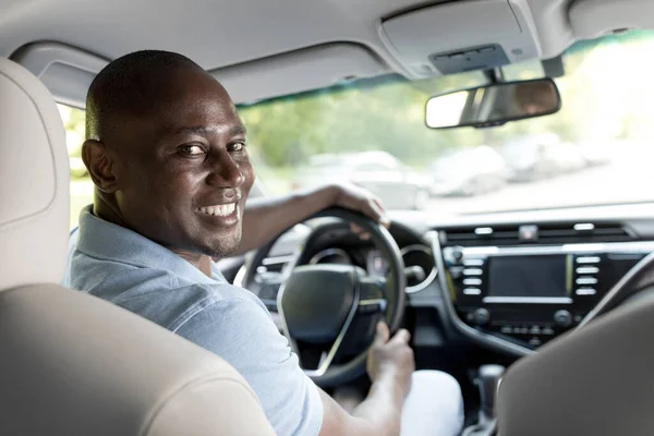 Mosolygó fekete srác sofőr ül benne vadonatúj autó — Stock Fotó