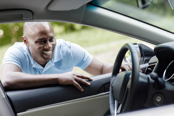Ευτυχισμένος αφρικανός αμερικανός πελάτης που κοιτάζει μέσα στο νέο αυτοκίνητο — Φωτογραφία Αρχείου