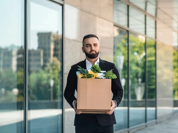 El hombre está molesto por el despido, perdió su trabajo. Despedido trabajador masculino que se muda de oficina con la caja llena de pertenencias, espacio de copia — Foto de Stock