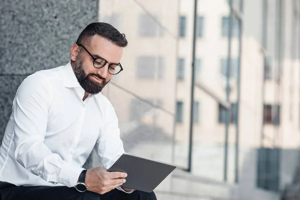 Empresário maduro bem sucedido confiante com tablet digital sentado perto do centro de escritório durante o intervalo, espaço de cópia — Fotografia de Stock