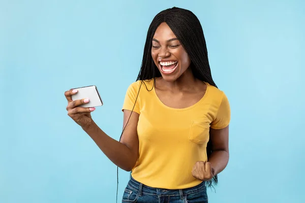 Mujer afroamericana con gestos de teléfonos inteligentes Sí sobre fondo azul — Foto de Stock