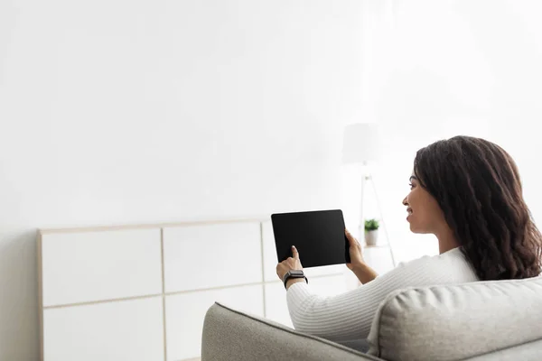 Concepto de hogar inteligente. Mujer millennial usando tableta digital con pantalla en blanco, ajustando los procesos de automatización de la casa —  Fotos de Stock