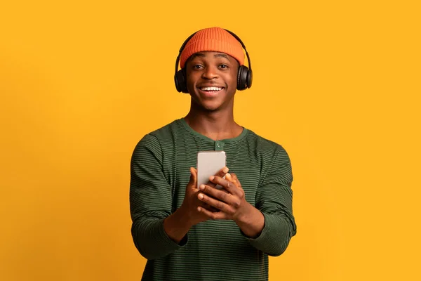 Positive Young Black Guy Listening Music With Wireless Headphones And Smartphone — Stock Photo, Image