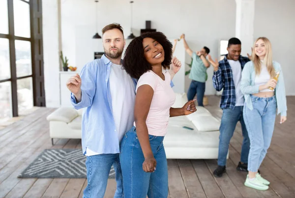 Multiraciaal jong stel feesten met hun diverse vrienden, dansen en bier drinken thuis — Stockfoto