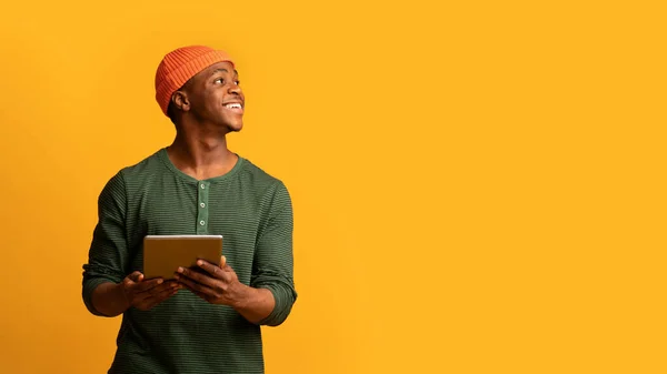 Çevrimiçi teklif. Dijital tablet tutan ve diğer tarafa bakan neşeli Afrikalı Amerikalı adam. — Stok fotoğraf