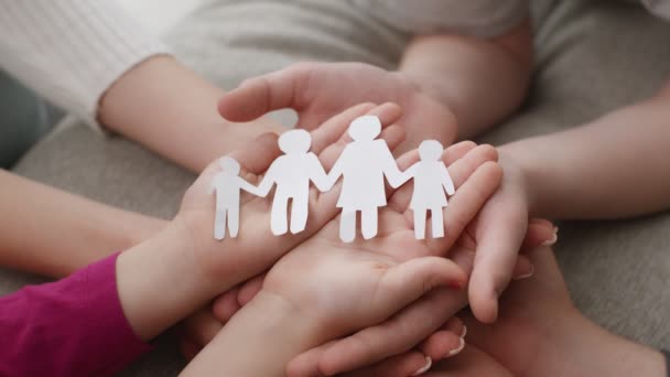 Happy family concept. Close up shot of cut united paper figures on stacked hands of children and parents — Stock Video