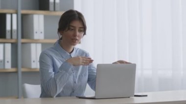 Genç kendine güvenen kadın iş ortaklarıyla bilgisayar uygulaması üzerinden görüntülü sohbet ediyor, gelecekteki ortaklığı tartışıyor.