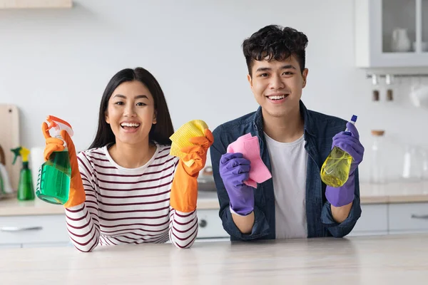 Positieve Aziatische liefhebbers schoonmaken keuken bij nieuw appartement — Stockfoto