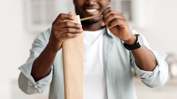 Feliz hombre afroamericano atornillando perno a la mesa de madera, instalando escritorio por sí mismo en casa, primer plano, cosecha —  Fotos de Stock