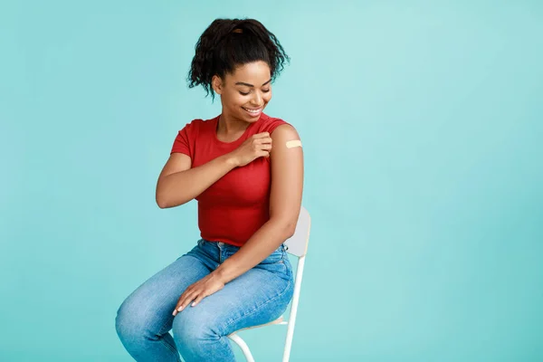 Prävention von Coronavirus. Afroamerikanische Patientin zeigt Schulter mit Pflaster nach Covid-Impfstoffinjektion — Stockfoto