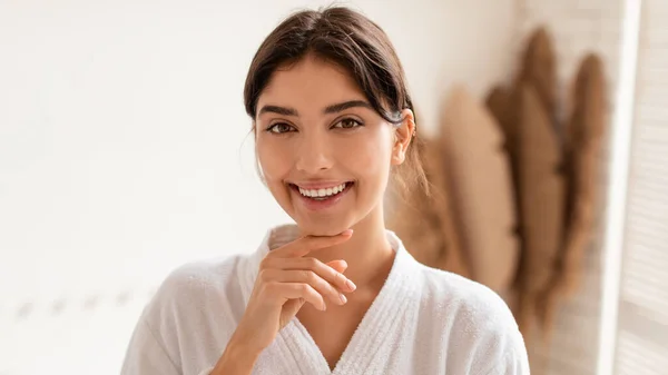 Mujer feliz posando sonriendo a la cámara tocando la cara en el baño —  Fotos de Stock