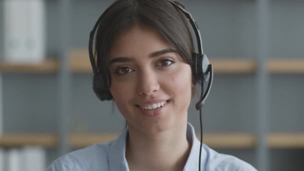 Online služba zákaznické podpory. Mladá přátelská dáma operátor nosí sluchátka mluvit se zákazníkem prostřednictvím videohovoru — Stock video