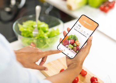 Siyah hamile kadın hamilelik için mobil uygulama kullanıyor.