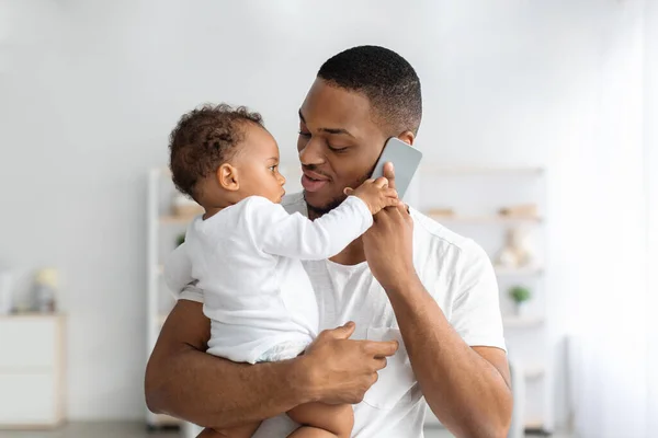 Adorable Little Black Baby Playing With Cellphone While Father Talking On It