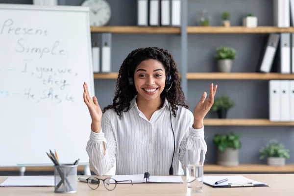 Vista de cámara web. Sonriente milenaria dama negra en auriculares, explica reglas, gestos —  Fotos de Stock