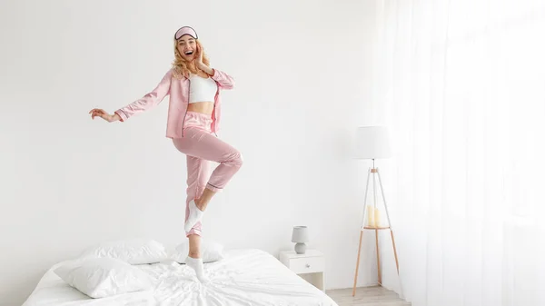 Donna in pigiama rosa in camera da letto bianca interno — Foto Stock