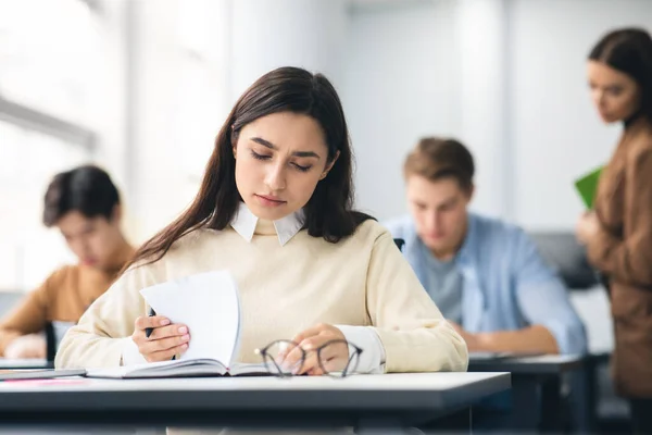 Estudiante sentada en el escritorio en el examen de escritura en clase — Foto de Stock