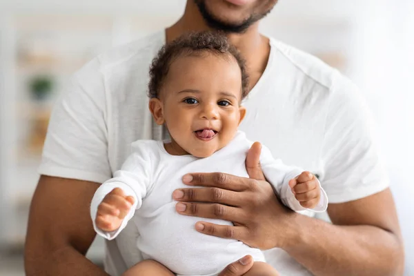 Zabawny Cute Black Baby Baby relaks w rękach ojców w domu — Zdjęcie stockowe