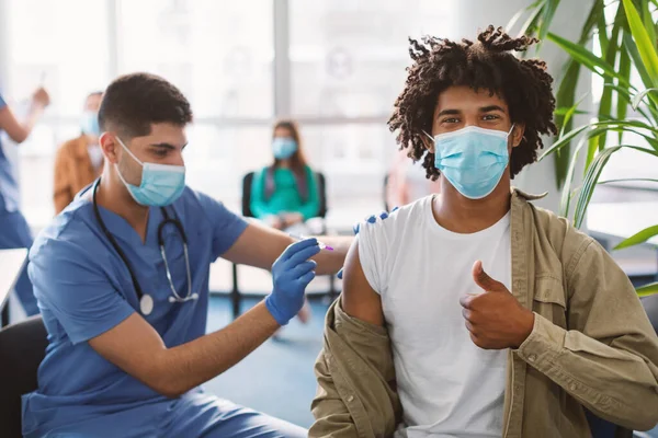 Schwarzer Mann mit Maske erhält Coronavirus-Impfstoff-Injektion in Klinik — Stockfoto