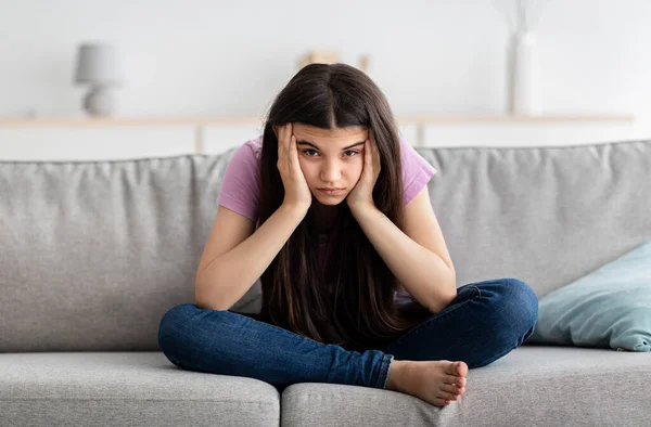 Upset Indian teenage girl sitting on couch, feeling bored, suffering from lack of communication, being trapped at home — Stock Photo, Image