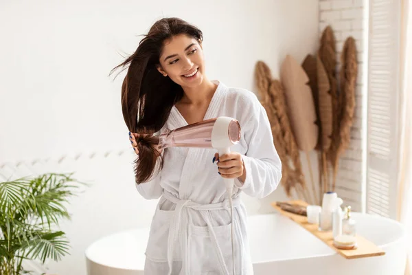 Mujer secado largo morena cabello usando secador de pelo en baño — Foto de Stock