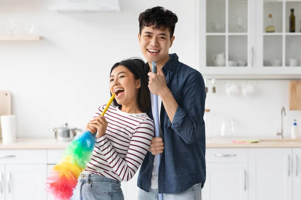 Feliz pareja china disfrutando de la limpieza, cantando canciones y bailando — Foto de Stock