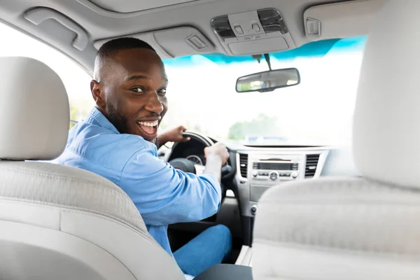 Sorridente uomo nero alla guida di auto nuove in città — Foto Stock