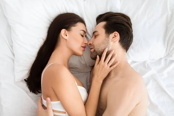 Vista superior de la pareja amorosa besándose haciendo el amor acostado en el interior — Foto de Stock