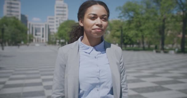 Zoom nel ritratto della giovane donna afroamericana sicura di sé in piedi nel parco urbano e rispondendo alla tanto attesa telefonata — Video Stock