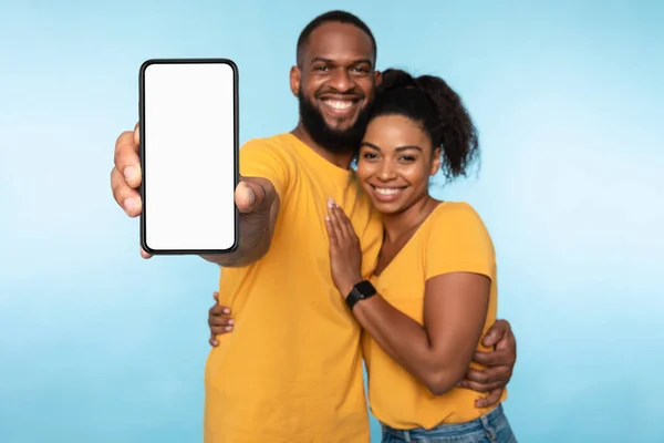 Aplikasi mobile baru yang mengagumkan. Pasangan Afrika-Amerika menghadirkan smartphone dengan mockup, mempromosikan aplikasi atau situs web — Stok Foto