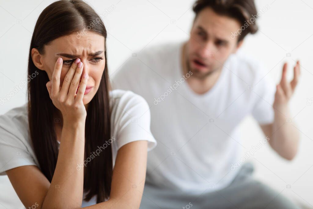 Aggressive Husband Shouting At Unhappy Crying Wife At Home