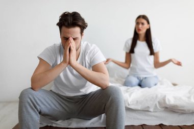 Koca, yatak odasında oturan eşiyle çatışmaktan yoruldu.