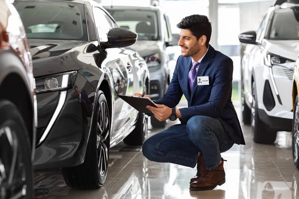Médio-oriental cara gerente de vendas no salão de auto fazer check-up — Fotografia de Stock