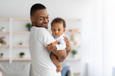 Mutlu siyah baba, tatlı bebeğiyle evde vakit geçiriyor.