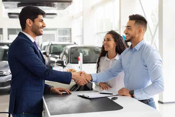 Sourire homme et femme du Moyen-Orient acheter une voiture au salon — Photo