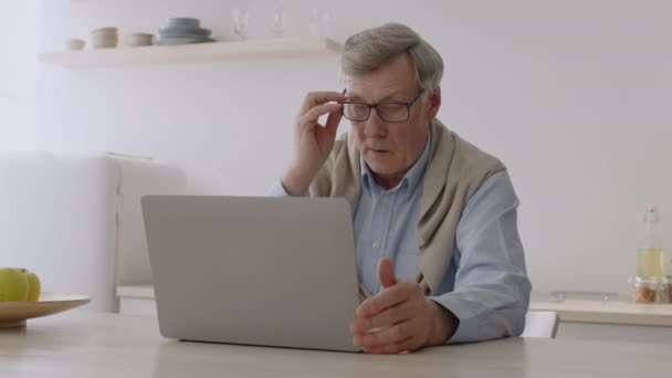 Старшеклассник работает над ноутбуком, испытывает проблемы с технологиями, снимает очки и трёт нос. — стоковое видео