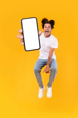 Beyaz boş akıllı telefon ekranı gösteren ve zıplayan adam