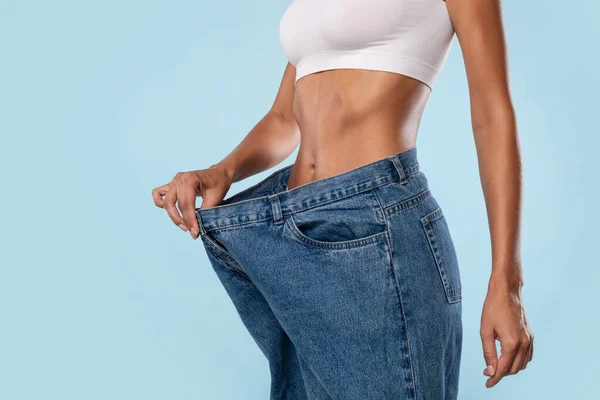 In der nähe von frau pulling sie alt groß lose jeans — Stockfoto