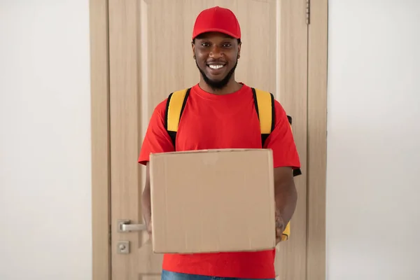 Negro entrega hombre celebración caja de pie en la puerta — Foto de Stock