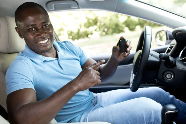 Szczęśliwy czarny człowiek pokazując klucz z jego nowy samochód — Zdjęcie stockowe