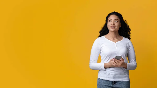 Aggressive junge schwarze Frau hält Smartphone in den Händen und schaut weg — Stockfoto