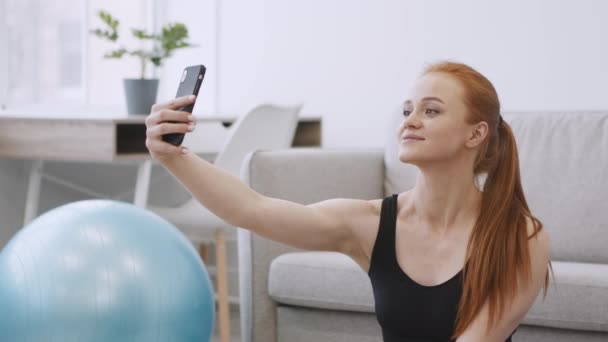 Sportieve vrouw Selfie maken op Smartphone tijdens de training thuis — Stockvideo