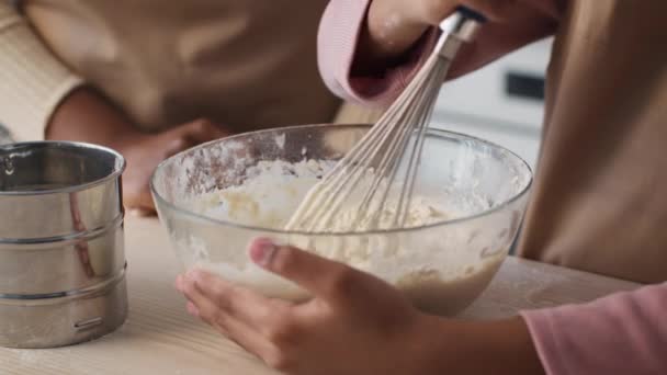 Melhor comida doméstica. Close up de irreconhecível menina afro-americana misturando massa crua na tigela, mãe de pé perto — Vídeo de Stock